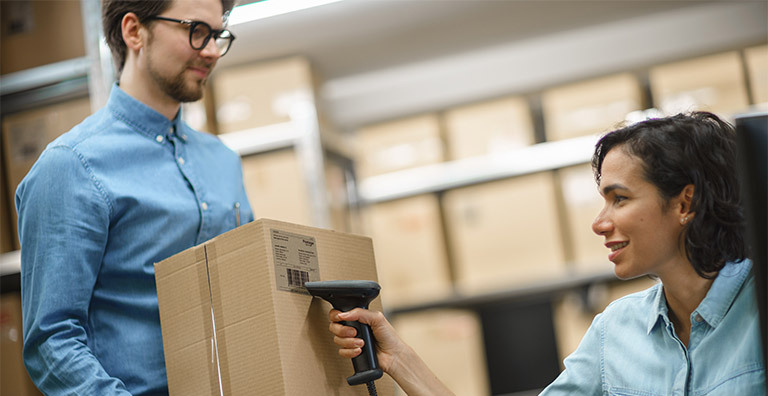woman scanning box in warehouse inventory management